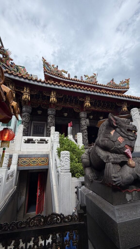 龍が彫り込まれた関帝廟の石の柱と獅子